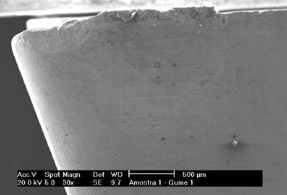 Desgaste atípico próximo à quina da ferramenta Mudança na direção de afiação entre o flanco e a quina Figura 3 Desgaste, atípico, próximo à quina do inserto TSV36, gume 1, aumento de 30x.