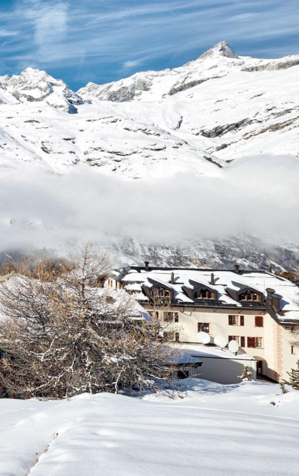 Uma vista ininterrupta de Riffelalp para os Alpes incluindo o Matterhorn - com os telhados do resort de cinco estrelas e a piscina exterior aquecida em primeiro plano.