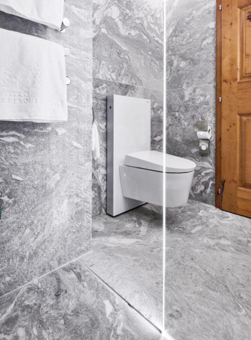 A calha Geberit CleanLine para duche fica harmoniosamente na área do duche, que apresenta grandes lajes de pedra natural.