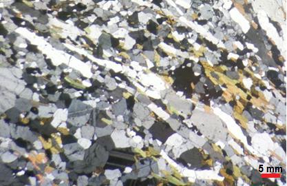 Figura 22: Fitas de quartzo em gnaisse milonítico. Figura 23: Deposição no contato entre os minerais. 8.3.2. Hornblenda plagioclásio gnaisse porfiroclastico A rocha possui textura granoblástica, porfiroclástica, com porfiroclastos de microclina, plagioclásio e anfibólio.