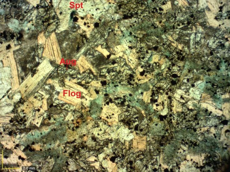 5.3 Lamprófiro A amostra de lamprófiro descrita possui uma textura porfirítica em matriz afanítica e estrutura maciça. Os fenocristais são de flogopita com inclusões de granada.