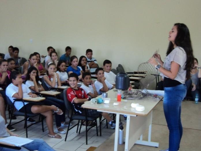Figura 1: Acadêmica da UFPR orienta os alunos da escola parceira, em Balneário Barra do Sul/SC, uma das dinâmicas de instrução sobre materiais comumente extraviados pela atividade pesqueira.