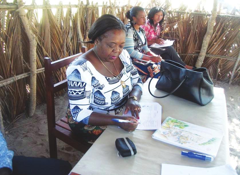 Imagem 13: Administradora do Distrito de Jangamo assinando o formulário numa cerimónia de devolução na comunidade de Maundza.