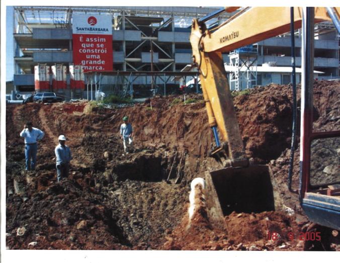 Foto 3 Exposição de material heterogêneo, com material bege pouco avermelhado na porção superior e um pouco mais escuro na parte inferior da parte mostrada na imagem.