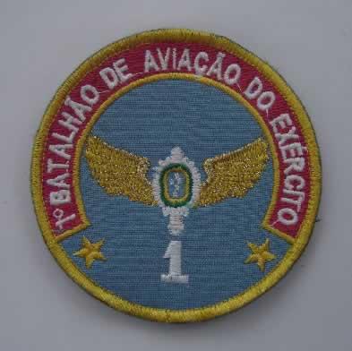 Fig 190-G (1) compõe de um escudo circular, com 93 mm de diâmetro; (2) no escudo circular com bordo em ouro, campo azul, cor representativa da Aviação do Exército, tendo em chefe um listel em arco e