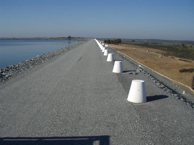 A geomembrana está envolvida por uma camada inferior de assentamento e de filtro em areia grossa, com 0,40 m de espessura e por uma camada superior de areia fina com 0,30 m de espessura.