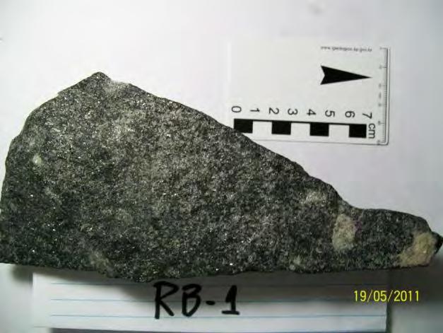 O quartzo também se apresenta amarelado devido a alteração da rocha, com granulação variando de fina a média. A biotita se apresenta extremamente alterada.