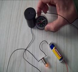 Possível explicação do aluno: O circuito está fechado por um fio condutor dentro da caixinha (3), porque a lâmpada acende, mas esse fio não é feito de um material ferromagnético, pois a agulha da