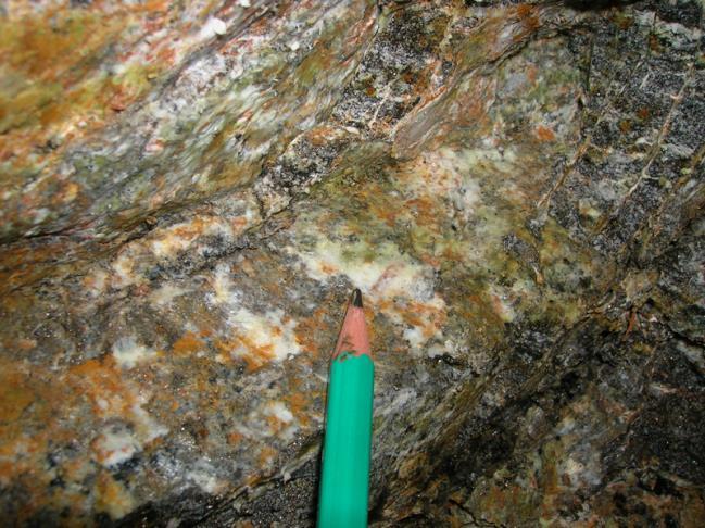 laranja, verde, marrom. É marcante a presença de cristais de calcedônia, de cor branca, verde e alaranjada e hábito fibroso e sedoso ao tato (Figura V.6).