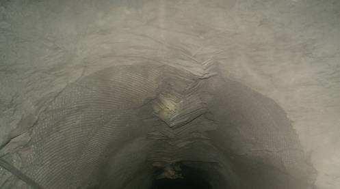 Figura 2.36: Buckling na parte superior do furo de ventilação (localizado no realce 15 Fonte Grande Sul lado direito, 900m de profundidade, da mina Cuiabá (Tropia, 2013).