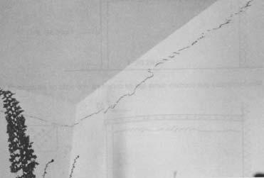 origem térmica. A figura 3.5 traz uma fotografia de uma parede que apresenta uma fissura de 72 Figura 3. 5 - Parede com fissuras evidenciando a dilatação térmica da laje de cobertura.