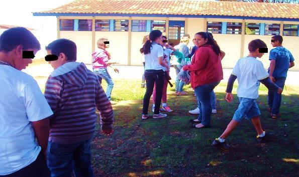 7 Após a divisão foi escolhido um representante de cada grupo, ambos tiveram os olhos vendados, e desta forma teriam que se deslocar a procura de peças espalhadas pelo pátio guiados pelo som das