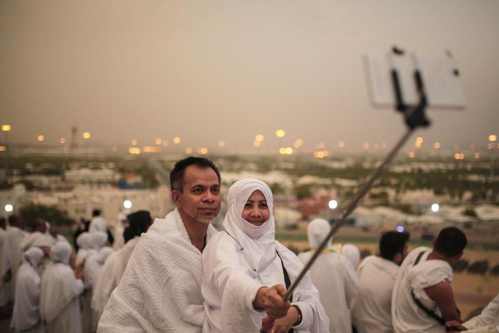 Casal de peregrinos fazendo uma selfie na planície de Arafat, perto da cidade de Meca. 2015.