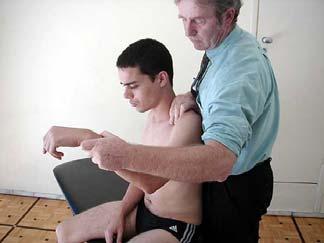 Coloca-se o ombro do paciente em rotação interna, o antebraço e a mão atrás do seu tronco, para