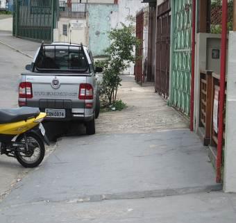 Rua Augusto Tolle, veículos estacionados sobre calçada.