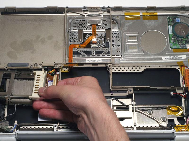 Passo 27 Remova o compartimento de placa PC Card, puxando-o para a direita e torcendo ligeiramente em