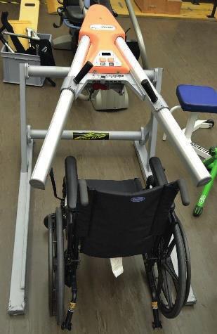 Monark Rehab Trainer 881E Os exercícios de força são realizados em uma multi-estação acessível para cadeira de rodas, polias de parede, pesos livres, e