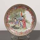 573 PRATO Em porcelana da China, decoração com esmaltes policromos e ouro com figuras em jardim. Marcado. Dim: 25,5 cm.