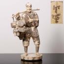 Base de licitação: 800 617 FIGURA ORIENTAL Escultura revestida a placas de osso entalhado, esgrafitado e colorido, assinada. Japão, Meiji. Dim.: 57 cm.