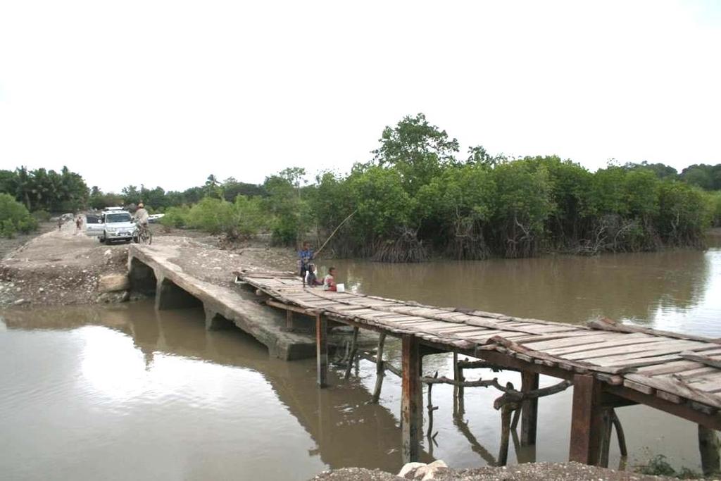 Figura 27 Ruínas de uma ponte de betão, sendo a travessia dos peões actualmente feita precariamente numa ponte de madeira em continuação do que restou da anterior estrutura (Suai-loro) Regista-se