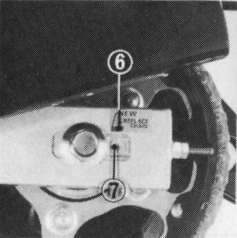 Verificação do desgaste da corrente Após ajustar a folga da corrente, verifique a etiqueta indicadora de desgaste da corrente (6) colada na extremidade do braço oscilante.