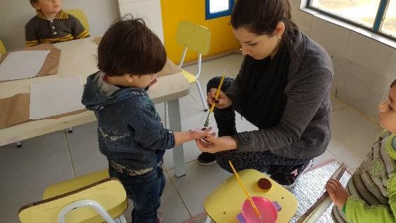 Logo em seguida me senti na mesa com eles e expliquei como iria ocorrer o trabalhinho do dia dos pais, então forramos a mesa, depois as professoras pintaram as mãos dos alunos e desenharam na