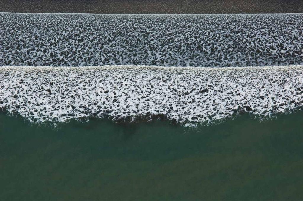 Linha de quebra de ondas numa praia durante a baixa-mar (visão zenital).