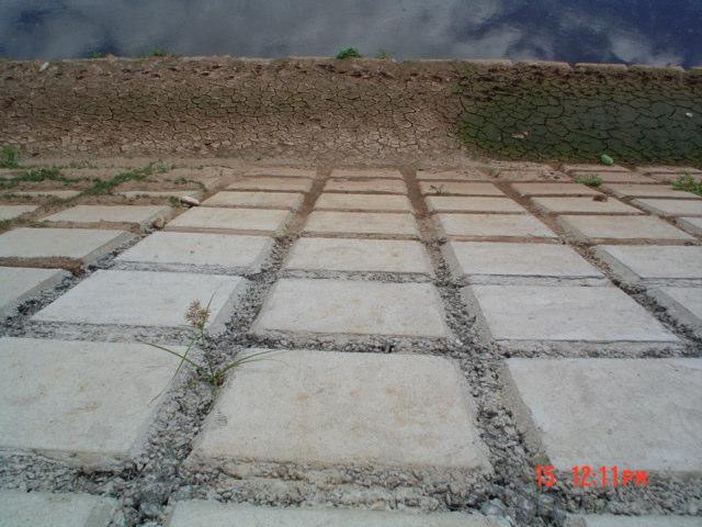 solo base, pela fuga de suas partículas através das placas ou concreto. Por isso o geotêxtil funciona como como filtro sob as juntas no caso das placas pré-moldadas ou concreto.