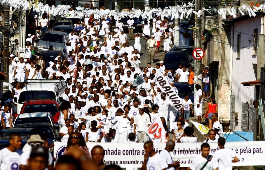 Membros de diversas terreiros de Candomblé da cidade, todos vestidos de branco, se reúnem no Engenho Velho da Federação e, partindo do final de linha do ônibus, caminham