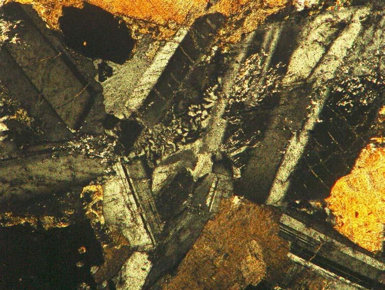 mq 2 mm Figura 5.4: Fotomicrografia mostrando textura mirmequítica (mq) em dique de diabásio da região de Santa Maria Madalena. Nicóis cruzados. Lâmina SMM-SV-1. 5.3 Composição mineral Os minerais foram divididos em três grupos, quais sejam: minerais essenciais, minerais acessórios e minerais secundários.