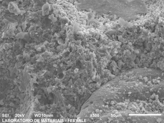 Figura 4- Micrografias de a) Argamassa com 0% de resíduo de palmilha micronizada, na idade de 7 dias, com resolução de 500 x; b) Argamassa com 15% de resíduo de palmilha micronizada na