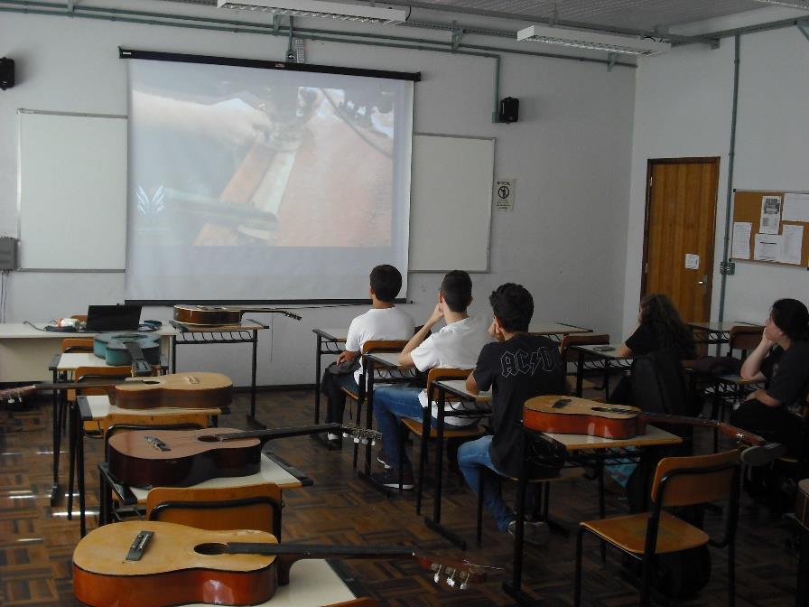 Figura 7 Exibição de um vídeo de um luthier construindo uma guitarra Após o vídeo os violões foram entregues a cada aluno e inicialmente puderam