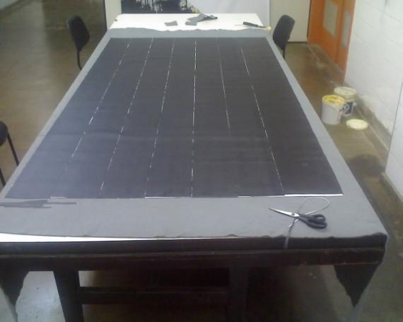 (b) colocação dos recortes da manta de PVC sobre o pano de manta de PVC engraxada, (c) aplicação da camada de vaselina sobre as tiras de