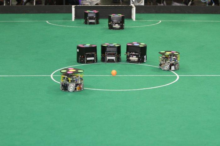 jogadores, da bola, etc.) [9]. Na figura 2.2 vemos um exemplo de jogo desta competição. Figura 2.2: RoboCup - Liga de robôs de tamanho pequeno [10].