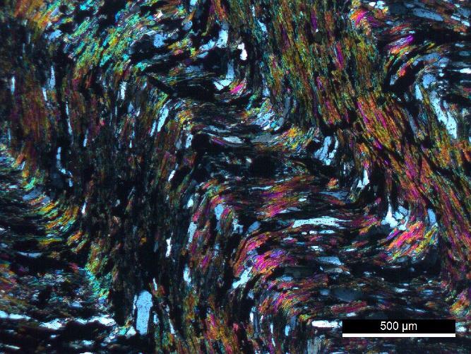 apresentando turmalina como mineral acessório (Fig. 4.103). Fig. 4.103 Microfotografia de um grão de turmalina, em matriz quartzo-sericítca (N//).