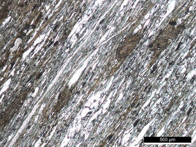 106 A B Fig. 4.111 Microfotografia de um pórfiro de biotite em N// (A) e em MX (B). Estes porfiroblastos são ligeiramente poicilíticos, possuindo inclusões de outros minerais.