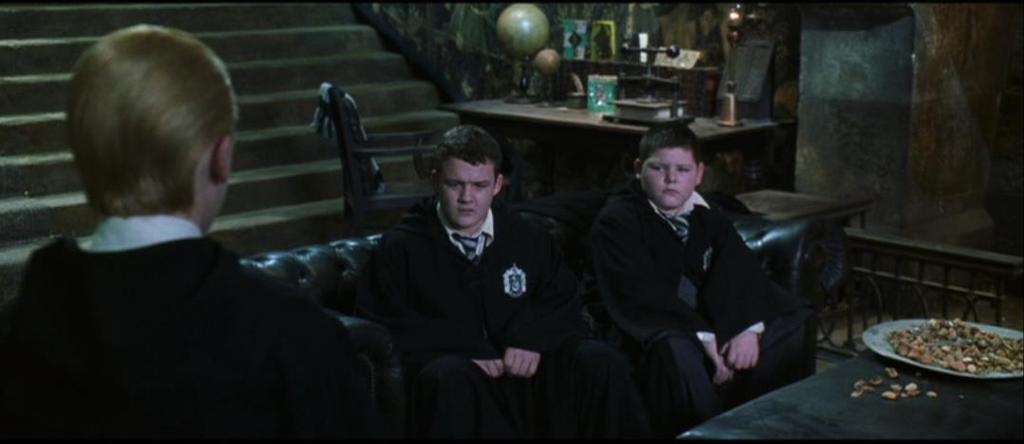 160 Imagem 71: Harry/Goyle olha com estranhamento para o bolso de Draco, após ele esconder o presente que encontrou.