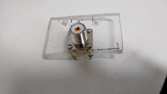 Isolador de acrílico e conector coaxial. Abraçadeiras. Foram confeccionadas duas abraçadeiras para serem fixadas na chapa de acrílico de modo a abraçaremos dois tubos de cobre. nos tubos.