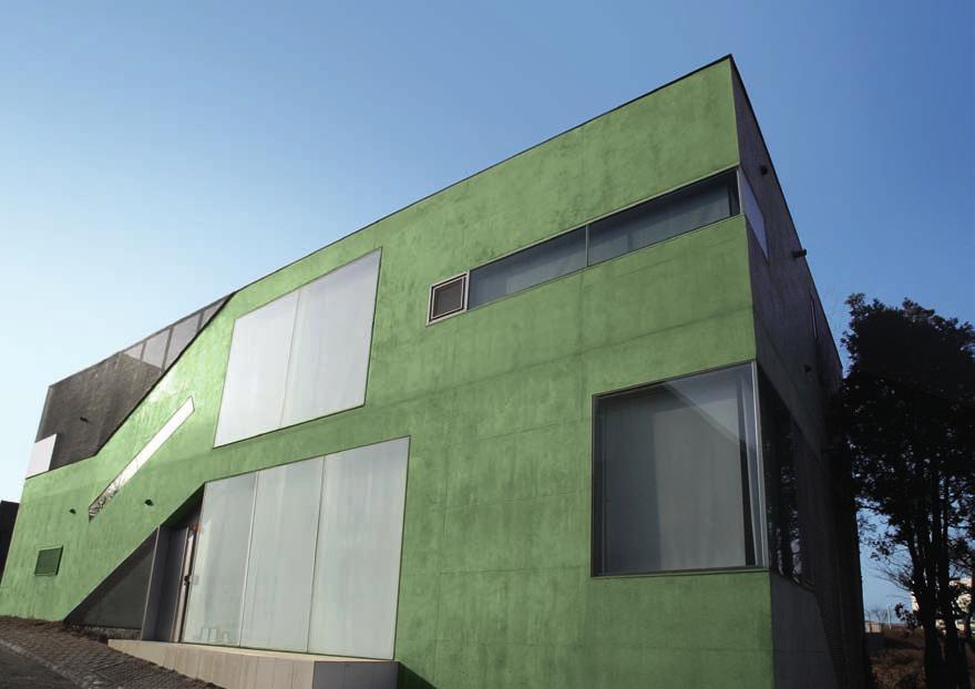 Uma das várias casas particulares de formas cúbicas, na Heyri Art Village, com fachadas em concreto verde (óxido de cromo verde).