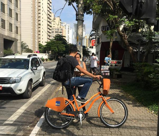 Ciclista com bicicleta compartilhada na