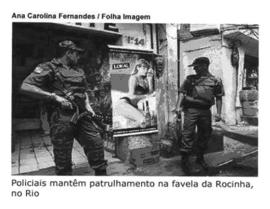 SARA OLIVEIRA Anexo 2 A foto traz a seguinte manchete: Policiais mantêm patrulhamento na favela da Rocinha, no Rio.