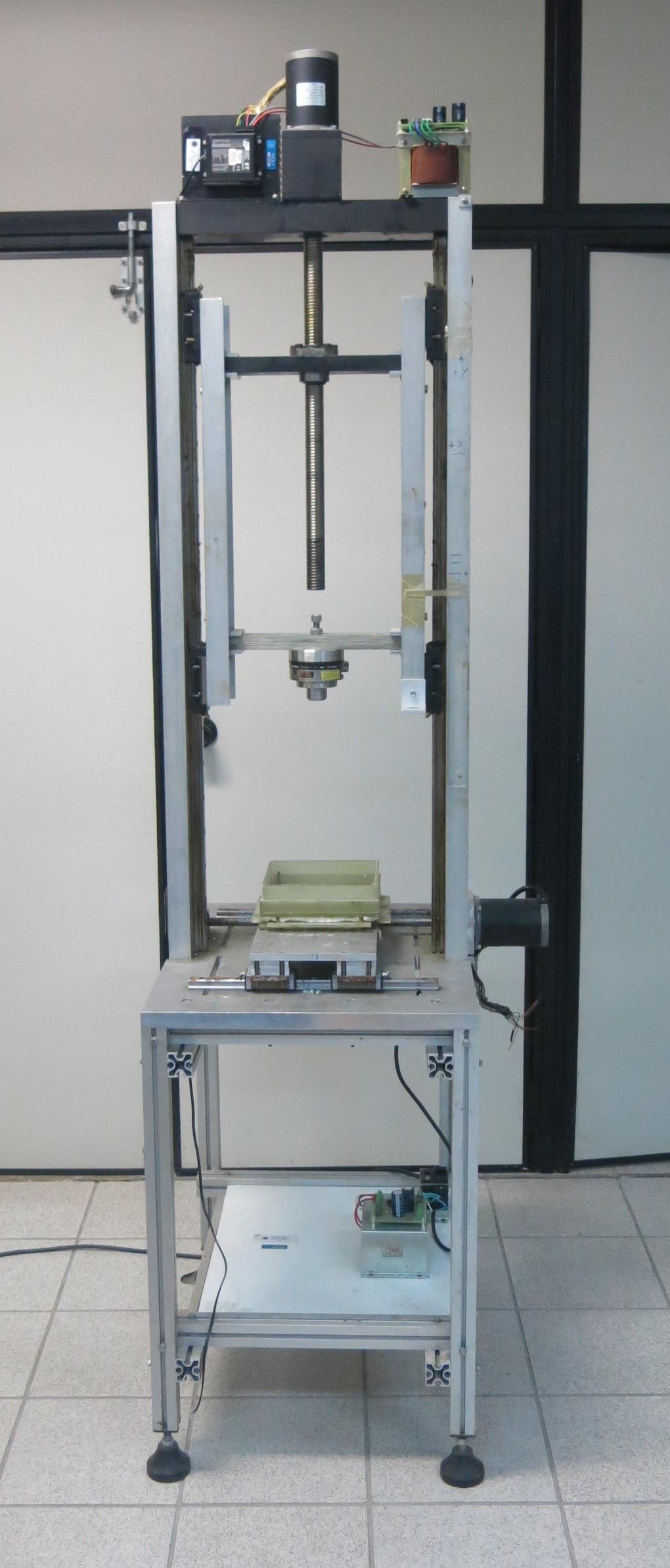 Figura 3.5: A bancada do sistema de medidas que não interfere no ensaio. O supercondutor é o material escuro marcado com um T no centro do recipiente.