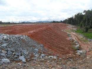 Detalhe da saia de aterro mostrando, de jusante para montante, os seguintes dispositivos: dique perimétrico em rocha, saia de