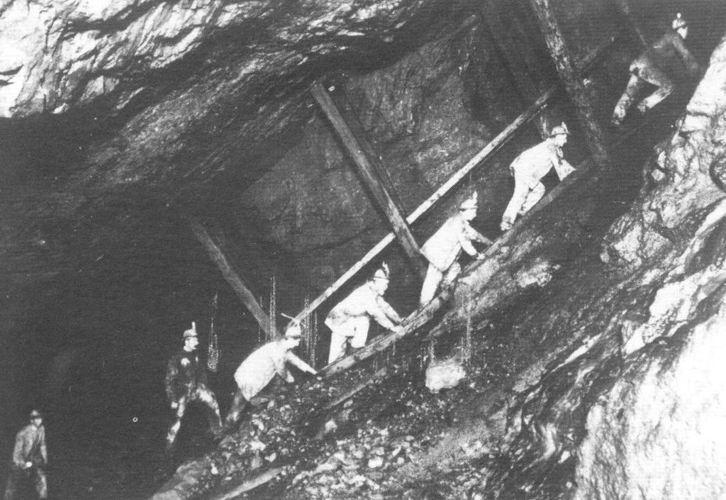 Os mineiros do novo turno agrupam-se à saída das casas da malta, buscam os lampiões, enquanto o guarda verifica o número e a conservação, penduram o gancho na jaleca, enterram o boné na testa com a