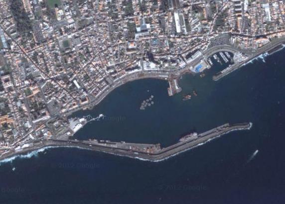 Introdução (a) (b) Figura 1.2 Molhe de São Miguel, Açores, vista panorâmica (a) (fonte: Google maps) e no local (b) Os quebra-mares, Figura 1.