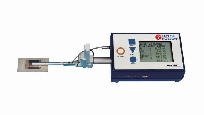 33 L c = 0,80 mm. O apalpador possui uma ponta com raio de 5μm, oferecendo uma resolução de 0,01 μm, com precisão de 2% do valor medido. As medições foram realizadas na direção longitudinal. Figura 3.