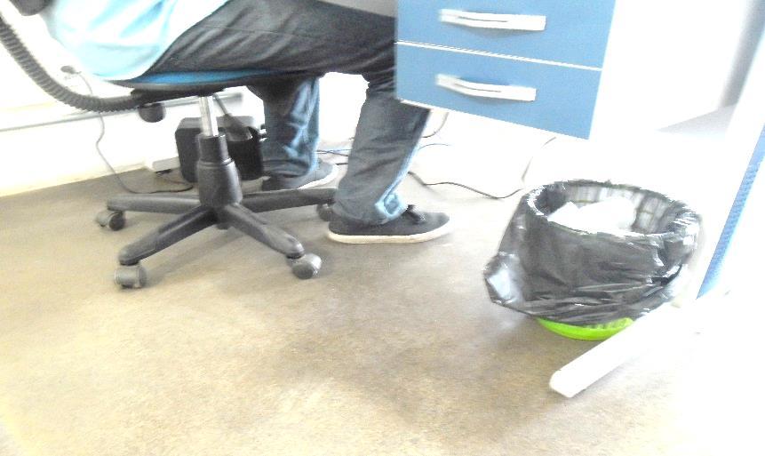 baixo. Colaborador sentado em seu posto de trabalho com apoio total dos pés no piso.