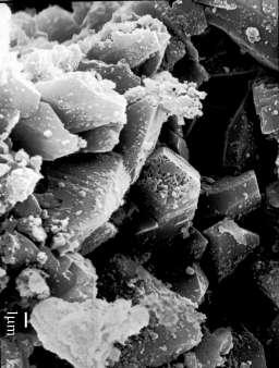 A figura 3 apresenta uma imagem da amostra de bauxita vista ao microscópio eletrônico de varredura. Essa analise permite identificar partículas de dimensão de 4 a 5 m com formato tabular e hexagonal.