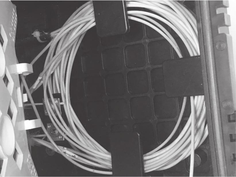 Acomode as sobras da fibra ao redor da bandeja de fusão e posicione o protetor de emenda no suporte, conforme imagem a seguir: 13