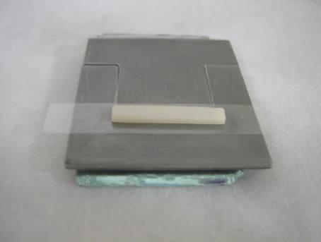 Foi empregada pressão até que a superfície inferior da placa cerâmica estivesse totalmente apoiada na superfície superior do molde metálico, eliminando-se todo o excesso de cimento.